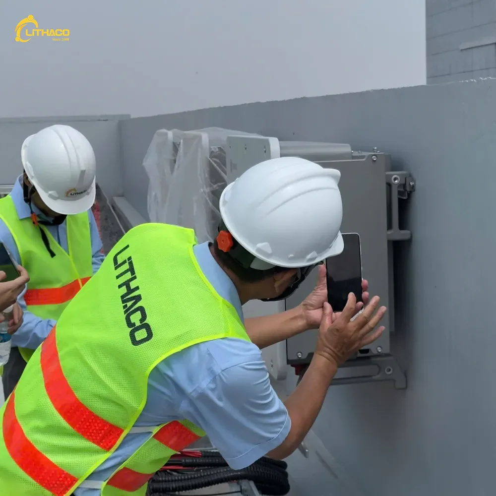 Ba kỹ sư LITHACO kiểm tra thiết bị hiện hữu trên tường sân thượng nhà máy, chụp lại thông số