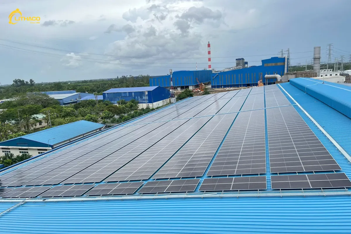 Mái tôn xanh khẩu độ lớn của một nhà xưởng đã phủ kín tấm pin, xa xa là dãy nhà xưởng khác
